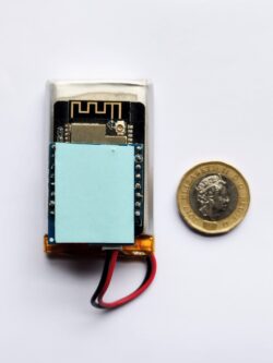 The McMatcher device shown next to a £1 coin. The McMatcher is approximately 2.5 times the length and 1.5 times the width of the £1. 